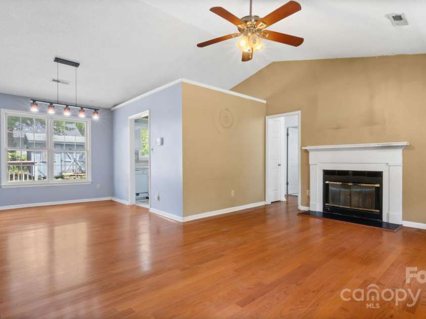 6915 Norchester Court, Charlotte, NC 28227.  MLS# CAR4250063, YatesRealty ID 8539. Large living and dining area have nice hardwood floors, vaulted ceiling, and cozy fireplace.