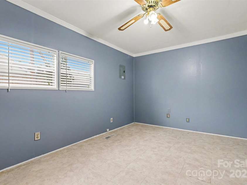 119 Moore Drive, Gastonia, NC 28056.  MLS# CAR4332115, YatesRealty ID 8565. Versatile bedroom (3) featuring neutral wall tones, durable flooring, and a ceiling fan with light for added comfort. Two windows provide natural light, creating a bright and functional space ideal for a bedroom, home office