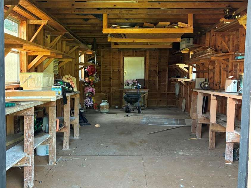 107 Mull Lane, Morganton, NC 28655.  MLS# CAR4225575, YatesRealty ID 8631. Inside of large storage building with workbenches and shelves