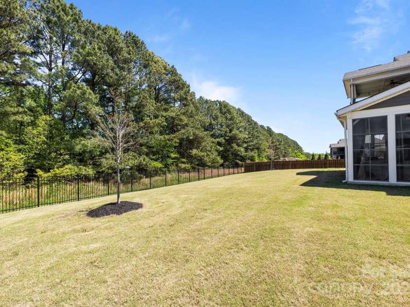 1052 Harlow's Crossing Drive, Weddington, NC 28104.  MLS# CAR4246716, YatesRealty ID 8684. Fenced back yard w/ wooded view
