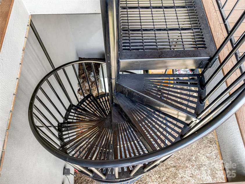 34 Grovepoint Way, Asheville, NC 28804.  MLS# CAR4228655, YatesRealty ID 8710. Spiral staircase from lower deck to waterfall and exterior patio area