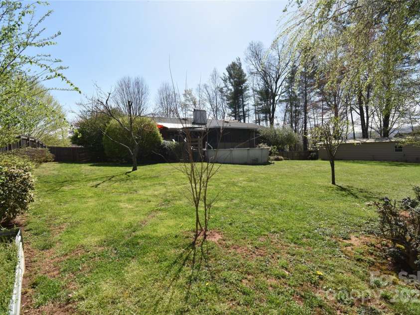 37 Hillside Drive, Etowah, NC 28729.  MLS# CAR4243156, YatesRealty ID 8761. Large fenced backyard with pool and workshop and lots to bloom this summer