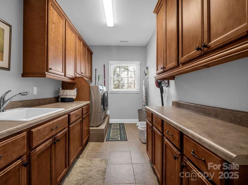 143 Lindsley Court, Hendersonville, NC 28792.  MLS# CAR4211464, YatesRealty ID 8821. Laundry room with washer and dryer, sink and plenty of work space.