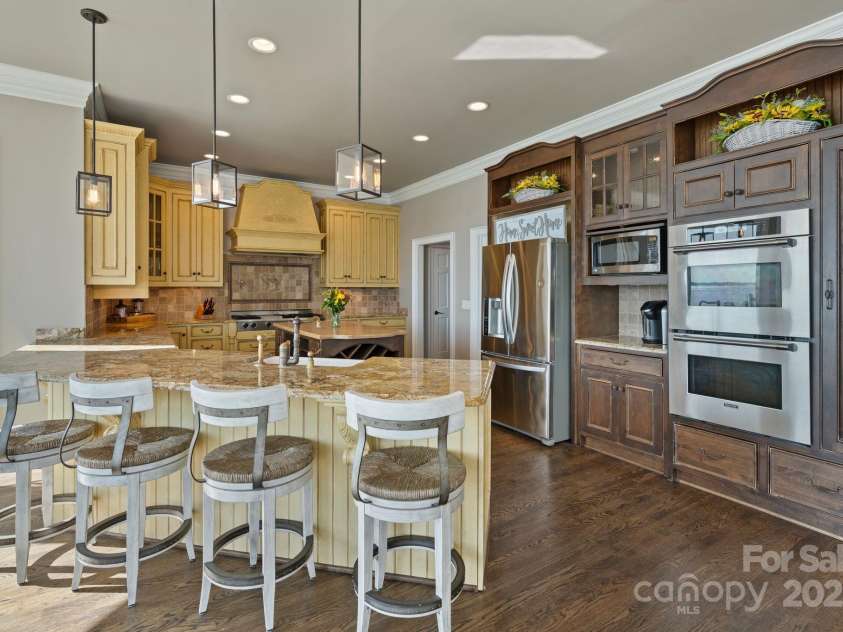 114 Ventana Court, Mooresville, NC 28117.  MLS# CAR4241186, YatesRealty ID 8842. Kitchen features stainless steel appliances, double oven, panty, and additional bar seating.