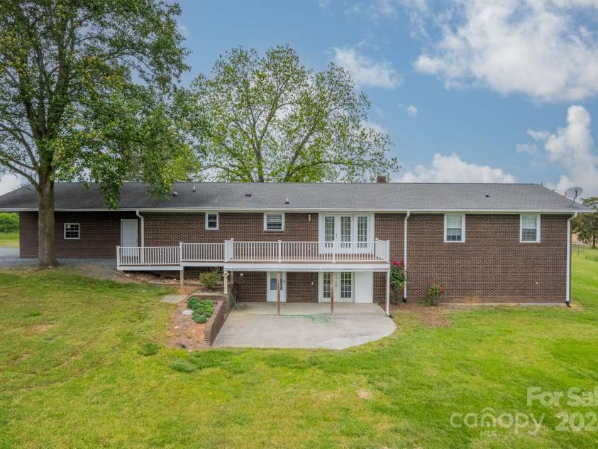 24686 Barbees Grove Road, Oakboro, NC 28129.  MLS# CAR4134946, YatesRealty ID 8851. Back of home with deck and partially covered patio.