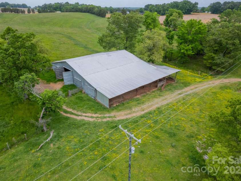 24686 Barbees Grove Road, Oakboro, NC 28129.  MLS# CAR4134946, YatesRealty ID 8851. Cow and hay barn