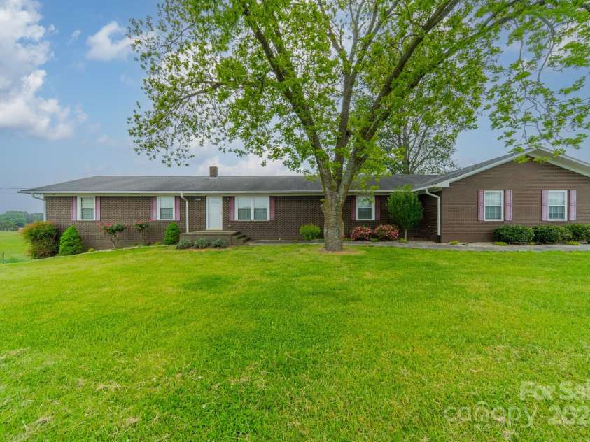 24686 Barbees Grove Road, Oakboro, NC 28129.  MLS# CAR4134946, YatesRealty ID 8851. Front of home featuring pecan trees and perfectly manicured landscaping.