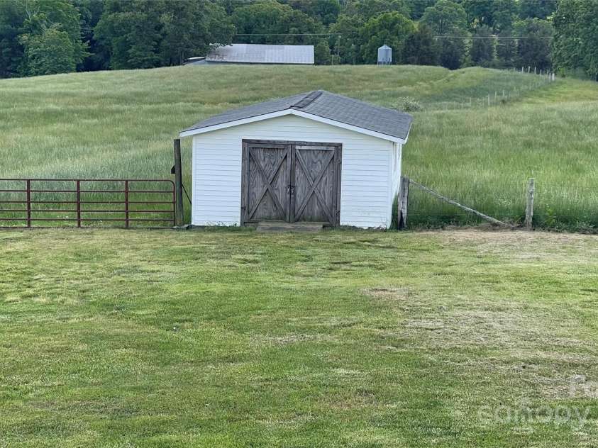 24686 Barbees Grove Road, Oakboro, NC 28129.  MLS# CAR4134946, YatesRealty ID 8851. Storage shed and gate to the pasture