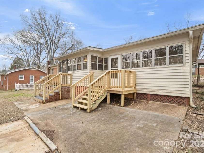 122 Lowry Row, York, SC 29745.  MLS# CAR4214035, YatesRealty ID 8886. Back of the home with a large concrete patio and two newly constructed wood deck/porches