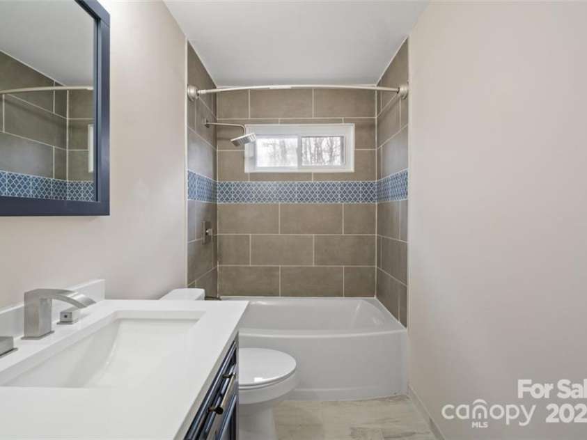 122 Lowry Row, York, SC 29745.  MLS# CAR4214035, YatesRealty ID 8886. Look at this beautiful recently updated bathroom - showcasing new tile flooring, ceramic tile surround in the tub with a transom window for natural lighting - new decorative furniture style double vanities and more ...