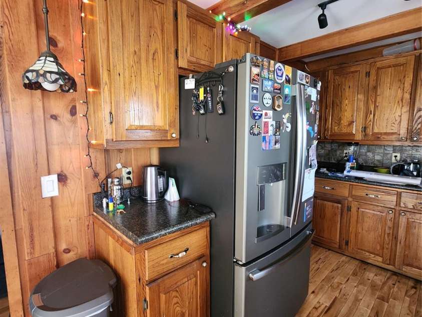 188 Paul Hurst Road, Franklin, NC 28734.  MLS# CAR4233199, YatesRealty ID 8897. Wood walls and cabinets. Refrigerator remains.