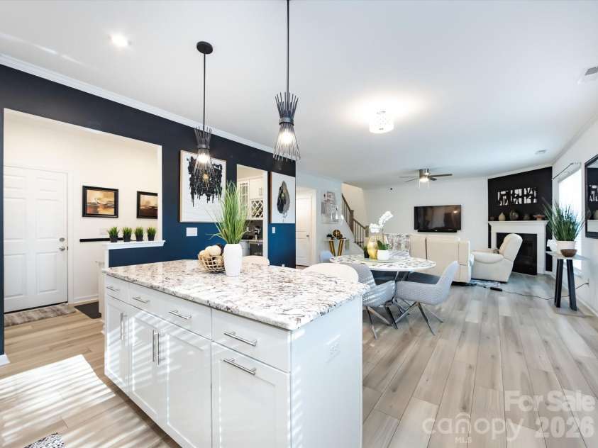 8903 Ansley Park Place, Huntersville, NC 28078.  MLS# CAR4366272, YatesRealty ID 8920. Alternate view of the kitchen showcasing granite countertops, gas cooktop with vent hood, stainless steel appliances, and crisp white cabinetry with stylish backsplash.