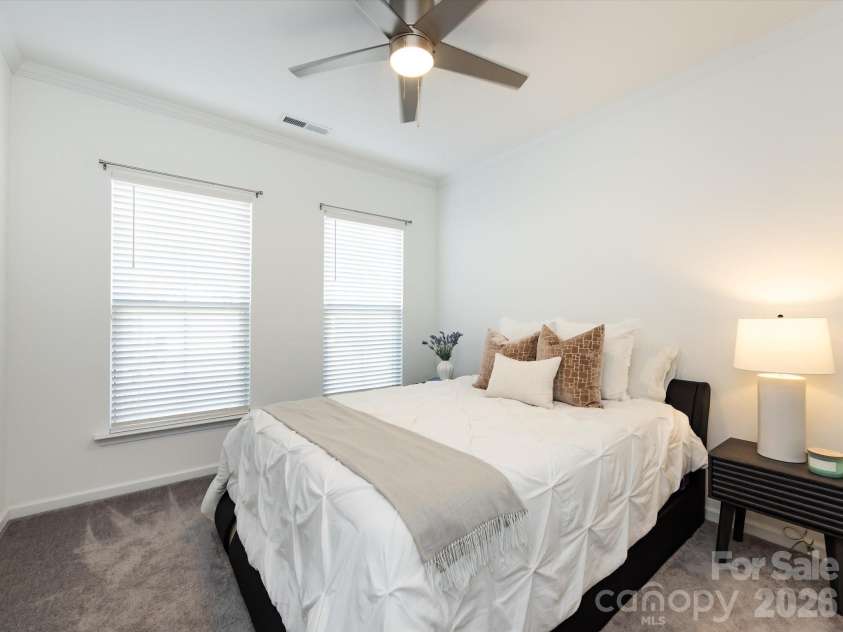8903 Ansley Park Place, Huntersville, NC 28078.  MLS# CAR4366272, YatesRealty ID 8920. Comfortable main-level guest bedroom with abundant natural light, neutral tones, and ceiling fan for added comfort.
