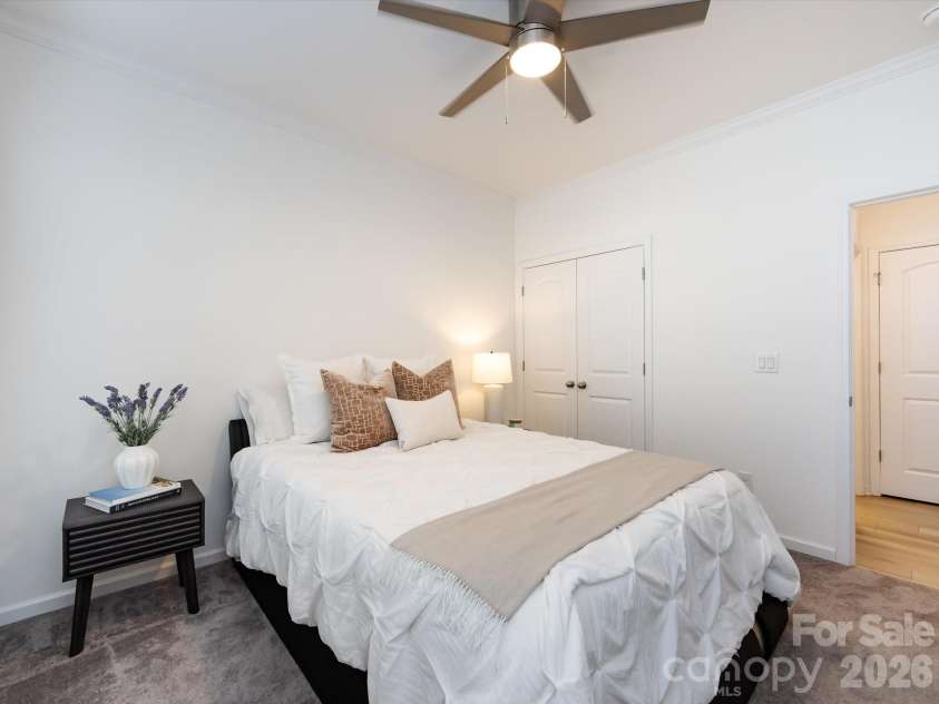 8903 Ansley Park Place, Huntersville, NC 28078.  MLS# CAR4366272, YatesRealty ID 8920. Comfortable main-level guest bedroom with abundant natural light, neutral tones, and ceiling fan for added comfort.