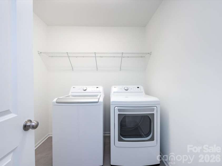 8903 Ansley Park Place, Huntersville, NC 28078.  MLS# CAR4366272, YatesRealty ID 8920. Convenient laundry room featuring washer and dryer with built-in shelving for added storage and organization.