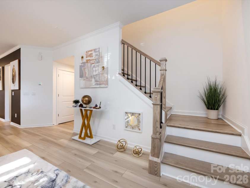 8903 Ansley Park Place, Huntersville, NC 28078.  MLS# CAR4366272, YatesRealty ID 8920. Open stairway to the upper level featuring modern railing, natural wood accents, and a clean, contemporary design that enhances the home’s flow.
