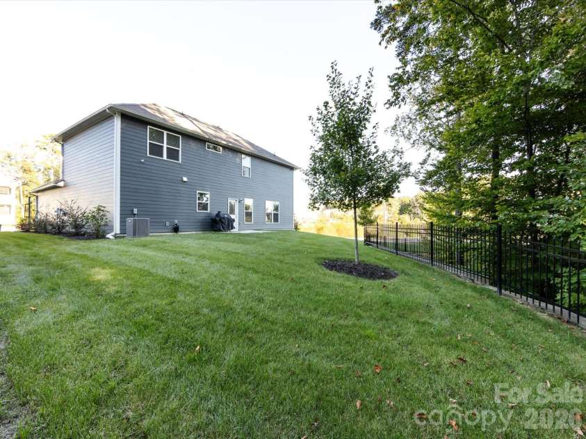 8903 Ansley Park Place, Huntersville, NC 28078.  MLS# CAR4366272, YatesRealty ID 8920. Spacious backyard with lush green lawn, mature trees, and fencing, offering privacy and room for outdoor enjoyment.