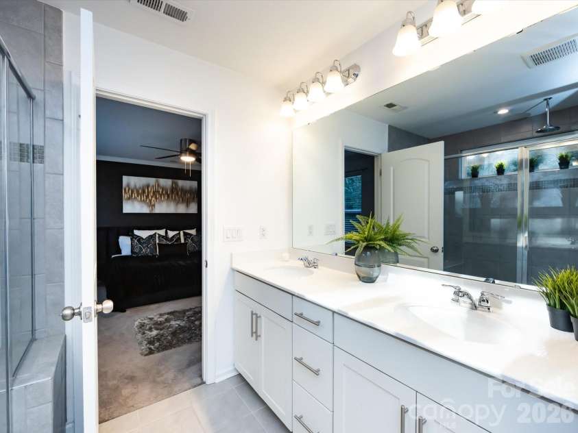 8903 Ansley Park Place, Huntersville, NC 28078.  MLS# CAR4366272, YatesRealty ID 8920. Spacious primary bathroom featuring a dual vanity, large mirror, and walk-in tiled shower for a clean, modern feel.