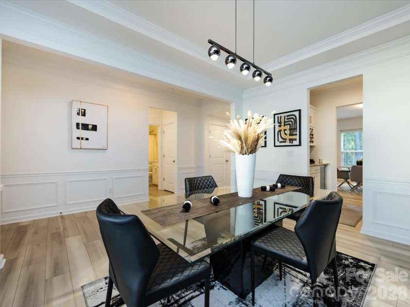 8903 Ansley Park Place, Huntersville, NC 28078.  MLS# CAR4366272, YatesRealty ID 8920. Stylish dining room featuring tray ceiling, wainscoting, and modern lighting, perfect for entertaining guests.