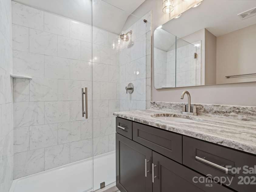 101 Mcalway Road, Charlotte, NC 28211.  MLS# CAR4321405, YatesRealty ID 896. Detail of beautifully tiled guest shower — designer finish throughout