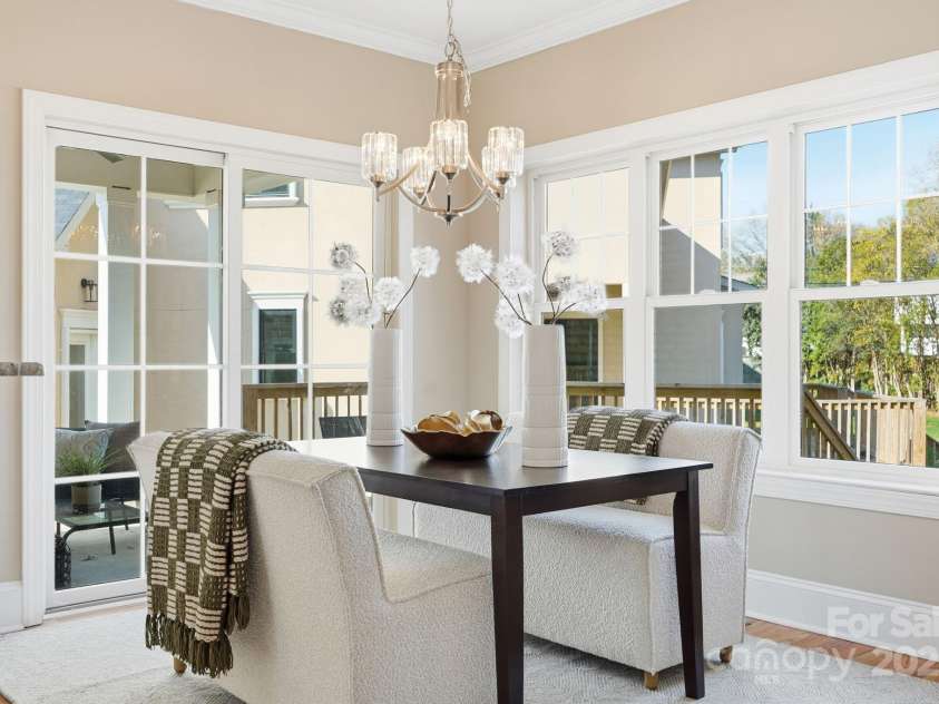 101 Mcalway Road, Charlotte, NC 28211.  MLS# CAR4321405, YatesRealty ID 896.  Elegant dining area with modern chandelier and views of the covered porch — perfect indoor/outdoor flow.
