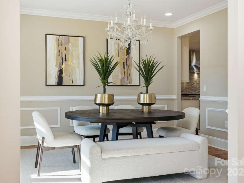 101 Mcalway Road, Charlotte, NC 28211.  MLS# CAR4321405, YatesRealty ID 896. Formal dining room with wainscoting, statement chandelier, and seating for entertaining.