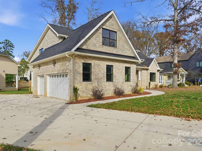 101 Mcalway Road, Charlotte, NC 28211.  MLS# CAR4321405, YatesRealty ID 896. Oversized driveway and two-car garage with carriage-style doors — abundant parking.