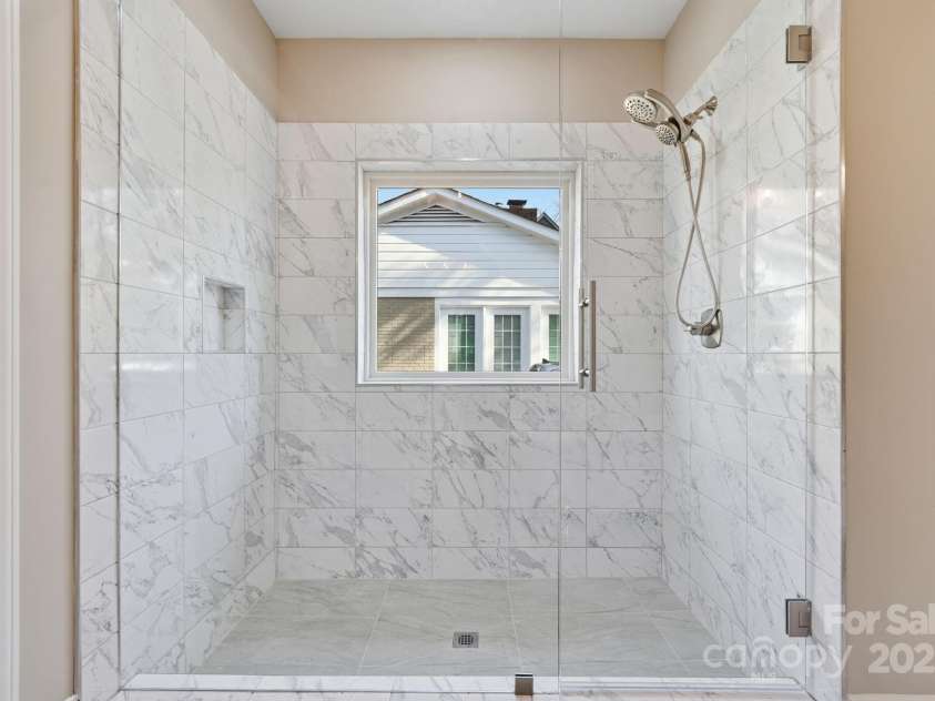 101 Mcalway Road, Charlotte, NC 28211.  MLS# CAR4321405, YatesRealty ID 896. Walk-in shower with seamless glass enclosure and upscale tile work.