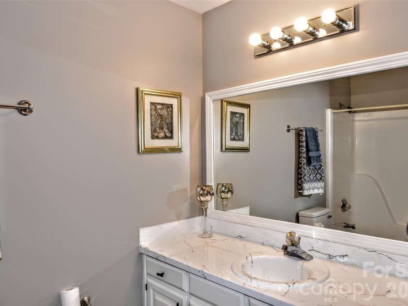 3916 Wonderland Drive, Matthews, NC 28104.  MLS# CAR4365192, YatesRealty ID 9002. Primary bath has large vanity with refinished sink and huge framed mirror. 