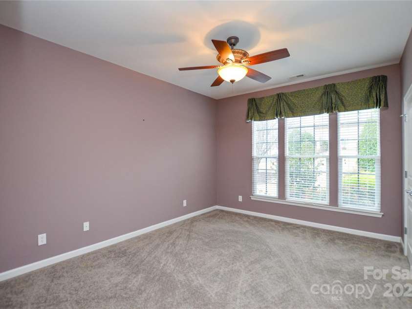 9332 Whistling Straits Drive, Fort Mill, SC 29707.  MLS# CAR4332758, YatesRealty ID 9098. 3rd bedroom with ceiling fan , wall of windows and its own ensuite bath