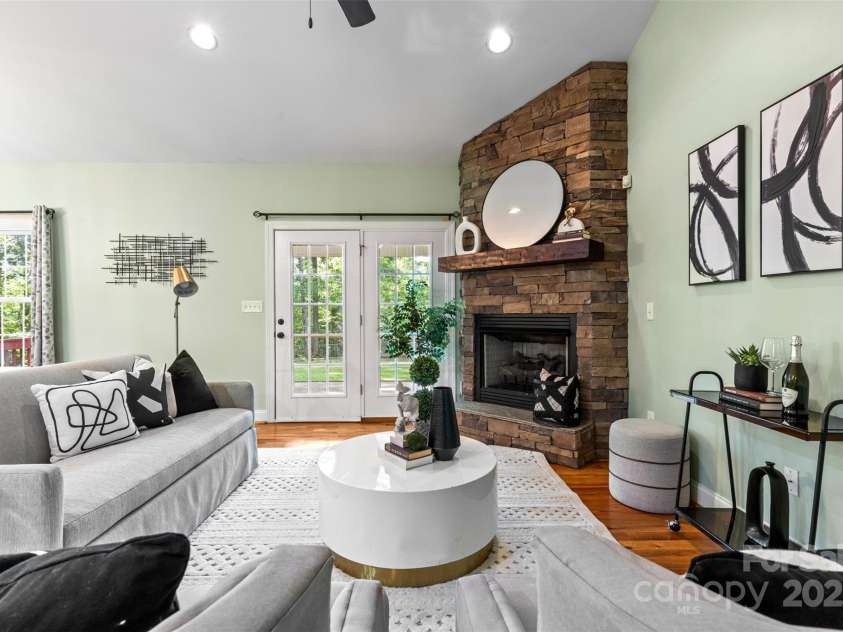 1313 Western Hills Lane, Vale, NC 28168.  MLS# CAR4272544, YatesRealty ID 9105. Cozy living area with fireplace and expansive windows overlooking the backyard.