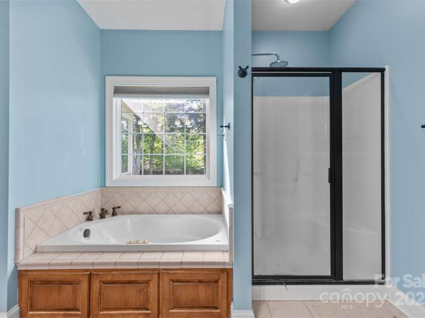 1313 Western Hills Lane, Vale, NC 28168.  MLS# CAR4272544, YatesRealty ID 9105. Luxury primary bath with dual vanities, soaking tub, and glass-enclosed shower.
