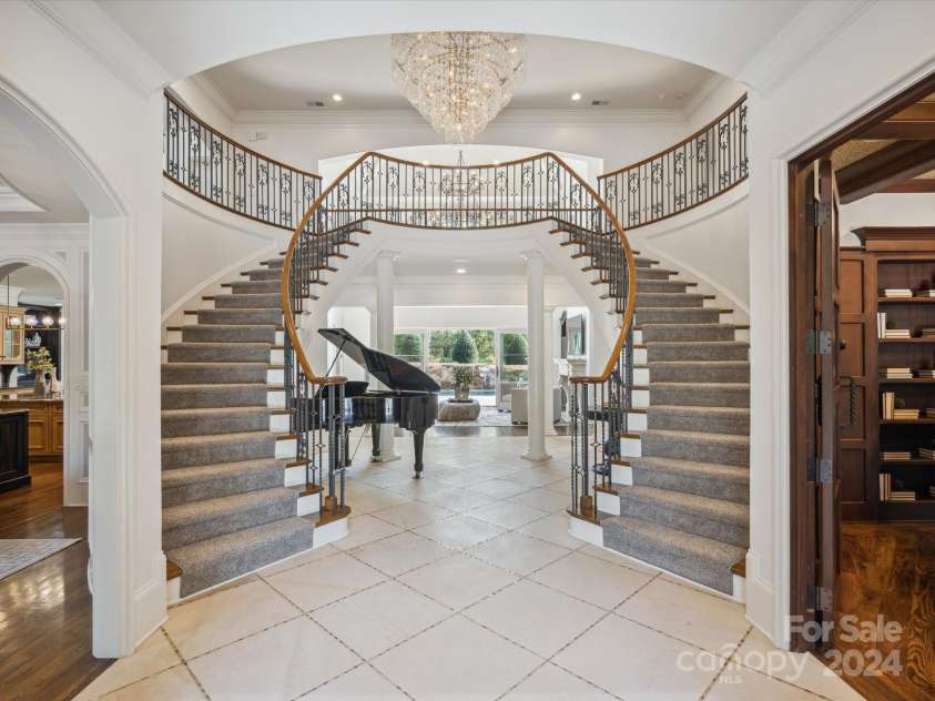 9044 Island Point Road, Charlotte, NC 28278.  MLS# CAR4135509, YatesRealty ID 912. Enter the majestic foyer, graced with a 'Romeo and Juliet' double staircase, towering ceilings, and an opulent chandelier that radiates elegance and luxury