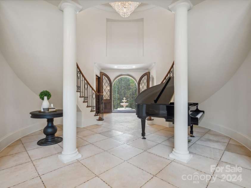 9044 Island Point Road, Charlotte, NC 28278.  MLS# CAR4135509, YatesRealty ID 912. Step into the grand foyer, featuring bespoke curved walls and stately pillars, presenting an elegant backdrop as you greet your guests—a space that epitomizes sophisticated welcoming