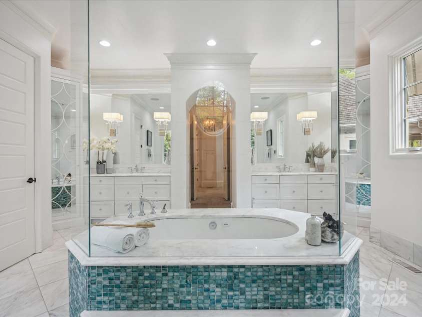 9044 Island Point Road, Charlotte, NC 28278.  MLS# CAR4135509, YatesRealty ID 912. The en-suite primary grand bathroom, boasting a grand, oversized shower and a luxurious soaking tub, designed for unparalleled relaxation and comfort