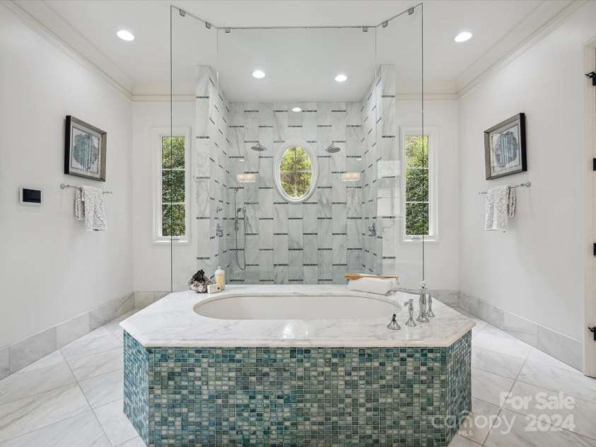 9044 Island Point Road, Charlotte, NC 28278.  MLS# CAR4135509, YatesRealty ID 912. The en-suite primary grand bathroom, boasting a grand, oversized shower and a luxurious soaking tub, designed for unparalleled relaxation and comfort