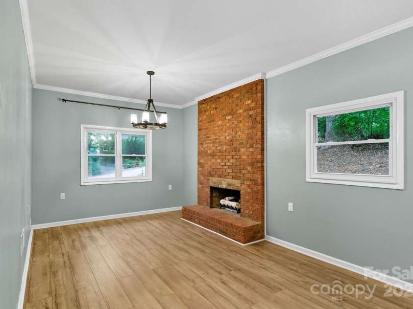 51 Campground Road, Asheville, NC 28805.  MLS# CAR4274929, YatesRealty ID 9303. Large den area with wood-burning fireplace with brick surround