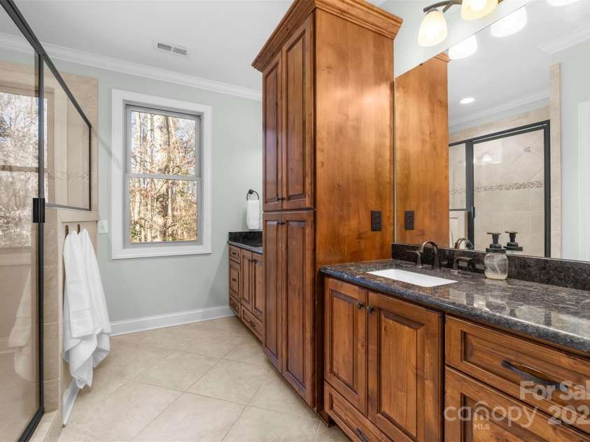 404 Yorkfield Drive, Shelby, NC 28150.  MLS# CAR4205572, YatesRealty ID 9353. Primary bath has a large walk-in tile shower and beautiful cabinetry with dual sinks.