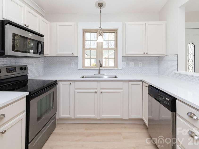 7 McGee Ridge Road, Fairview, NC 28730.  MLS# CAR4327576, YatesRealty ID 9362. Updated kitchen, with freshly painted .cabinets, new tile backsplash, and new Quartz countertops.