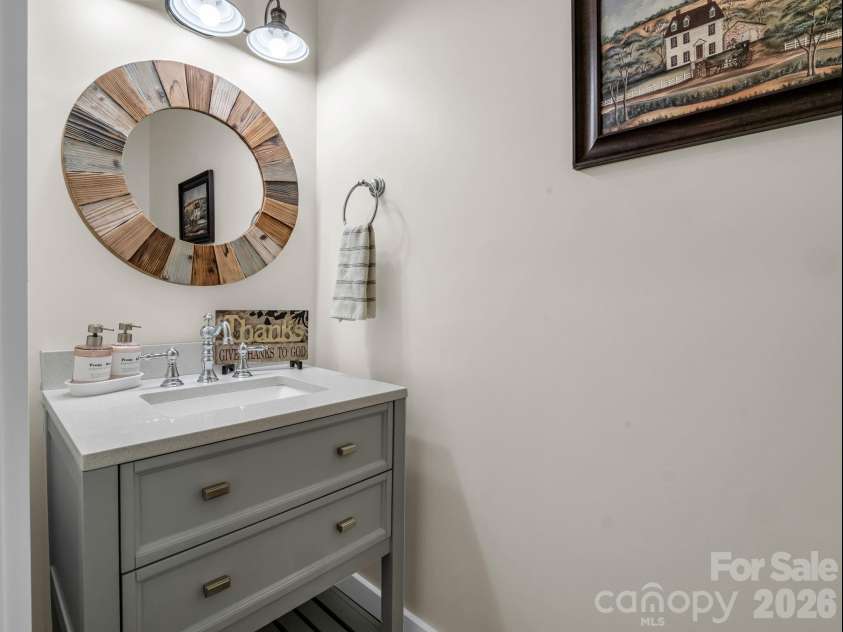 52 Old Spring Drive, Candler, NC 28715.  MLS# CAR4360930, YatesRealty ID 9363. Half bath is located near the kitchen across from the laundry room and pantry