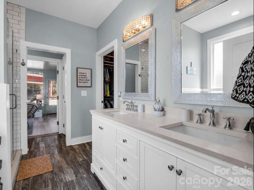 52 Old Spring Drive, Candler, NC 28715.  MLS# CAR4360930, YatesRealty ID 9363. Primary ensuite bath features dual sinks and granite counters, spacious walk-in closet just beyond the sinks and the door is easy access to the 3-seasons room