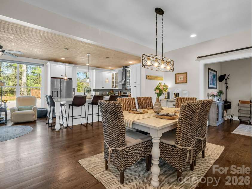 52 Old Spring Drive, Candler, NC 28715.  MLS# CAR4360930, YatesRealty ID 9363. View from stairs looking into the dining area and kitchen, see-through fireplace just behind the dining room table
