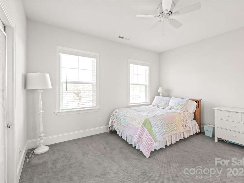 128 Shimmer Lake Lane, Belmont, NC 28012.  MLS# CAR4208573, YatesRealty ID 9390. A serene escape! Bedroom 3 features a walk-in closet, a Jack and Jill bathroom, and access to a private covered balcony—ideal for quiet moments and relaxation.