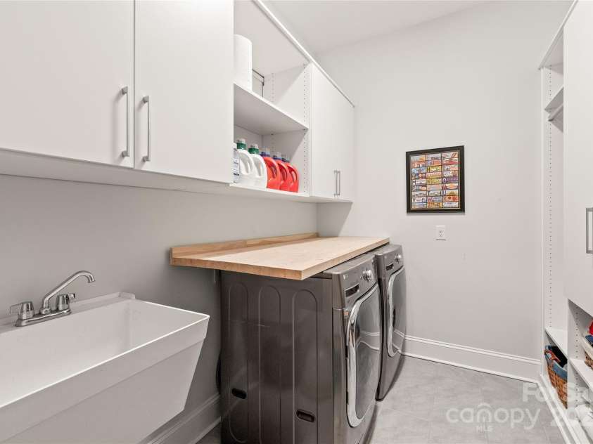 128 Shimmer Lake Lane, Belmont, NC 28012.  MLS# CAR4208573, YatesRealty ID 9390. Laundry day made easier! The walk-in laundry room features custom California Closet cabinets and a utility sink, combining style and functionality.