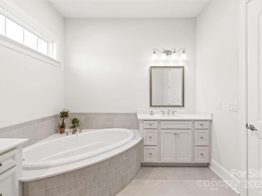 128 Shimmer Lake Lane, Belmont, NC 28012.  MLS# CAR4208573, YatesRealty ID 9390. Relax in style! The ensuite features double sinks with convenient drawers for easy access and a luxurious garden tub for ultimate relaxation.