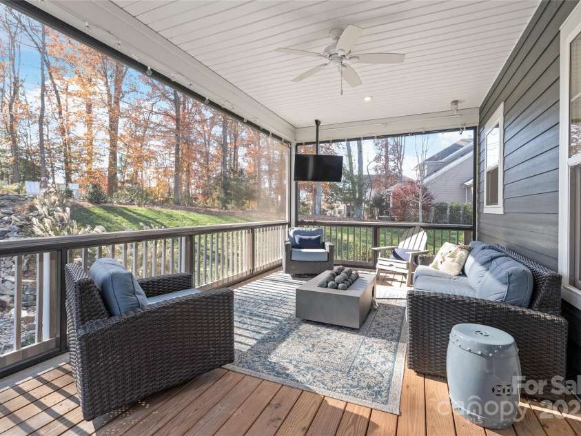 128 Shimmer Lake Lane, Belmont, NC 28012.  MLS# CAR4208573, YatesRealty ID 9390. Step outside to your private sanctuary: a custom screened-in porch, where the soft sound of a private waterfall and the warmth of a stone patio with a built-in grill invite relaxation and connection.