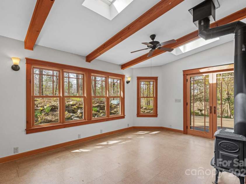 14 Woods Drive, Fairview, NC 28730.  MLS# CAR4223729, YatesRealty ID 9429. Sunroom with wood burning stove.