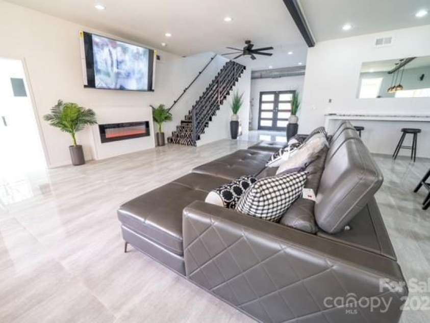 174 Crooked Creek Estates, Old Fort, NC 28762.  MLS# CAR4247439, YatesRealty ID 9447. The open concept living area with built-in electric fireplace blends seamlessly with the dining and kitchen space. Note the large entryway in the rear of the house. Downstairs is 1,905 sq ft of HLA.