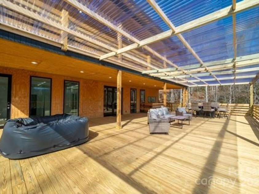 174 Crooked Creek Estates, Old Fort, NC 28762.  MLS# CAR4247439, YatesRealty ID 9447. This picture of the outdoor entertainment area showcases the large windows that bring the gorgeous mountain views inside.