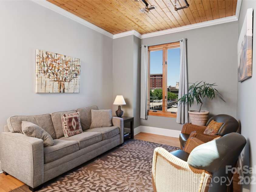 35 Patton Avenue, Asheville, NC 28801.  MLS# CAR4299187, YatesRealty ID 9493. Warm and inviting living room with window offering sweeping views of downtown AVL skyline, Grove Park Inn, and surrounding mountains.